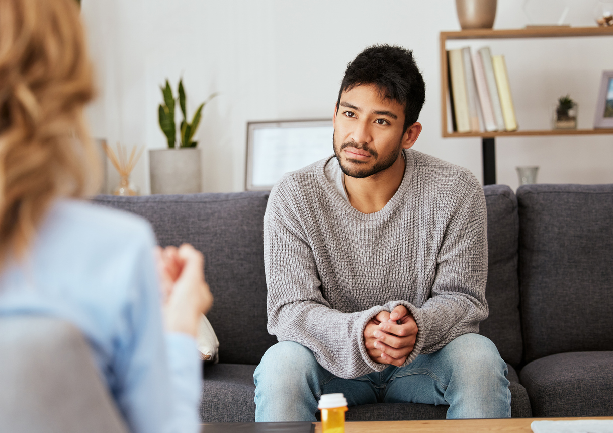 A man sitting in a counselling session.
