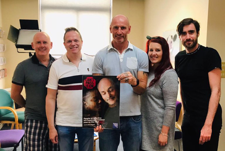 Gareth Thomas holding Can't Pass It On poster with THT staff Gareth Thomas holding Can't Pass It On poster with THT staff