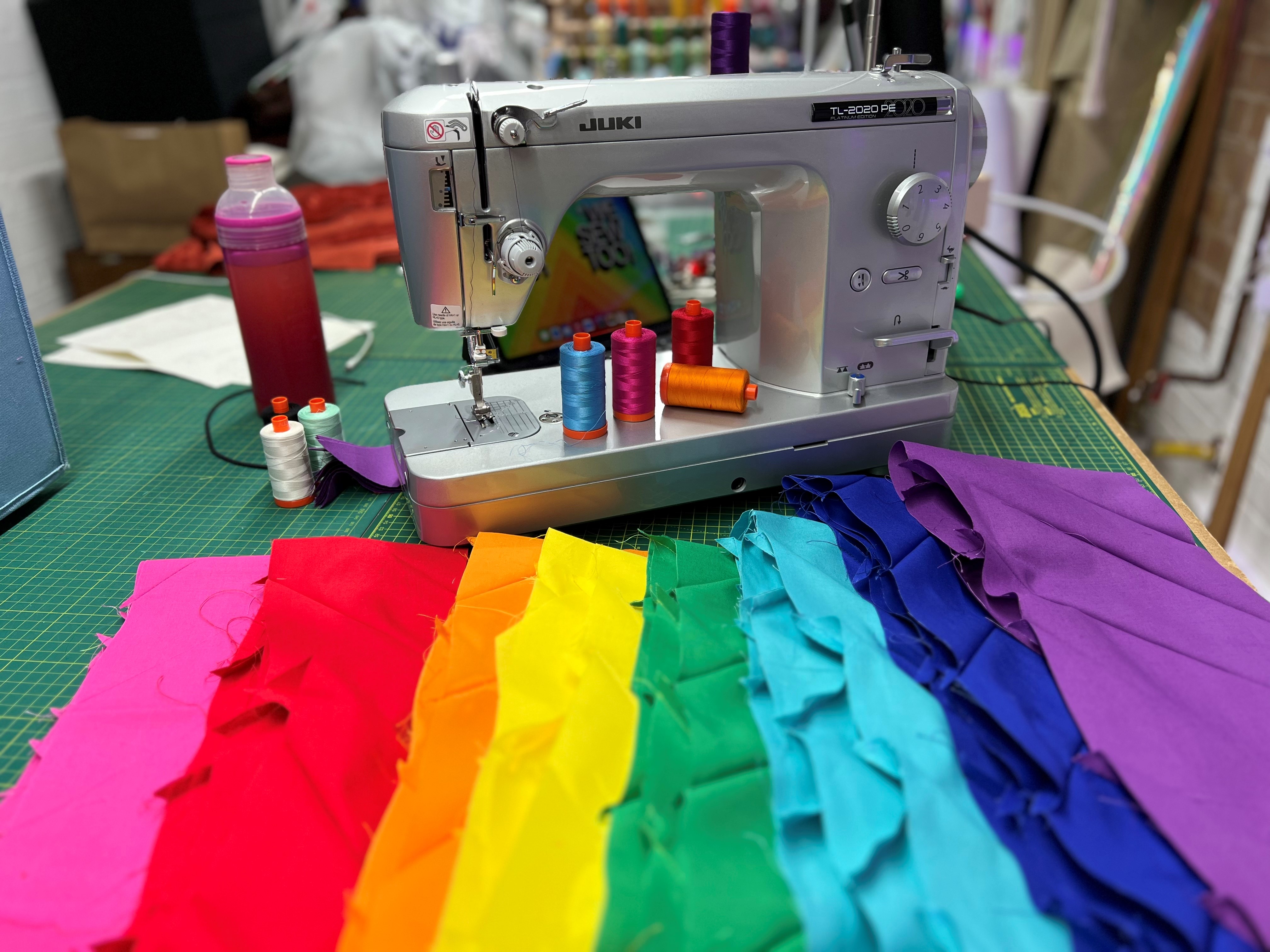 Terry Higgins AIDS Memorial Quilt Terry Higgins AIDS Memorial Quilt panel: a rainbow of fabric next to sewing machine