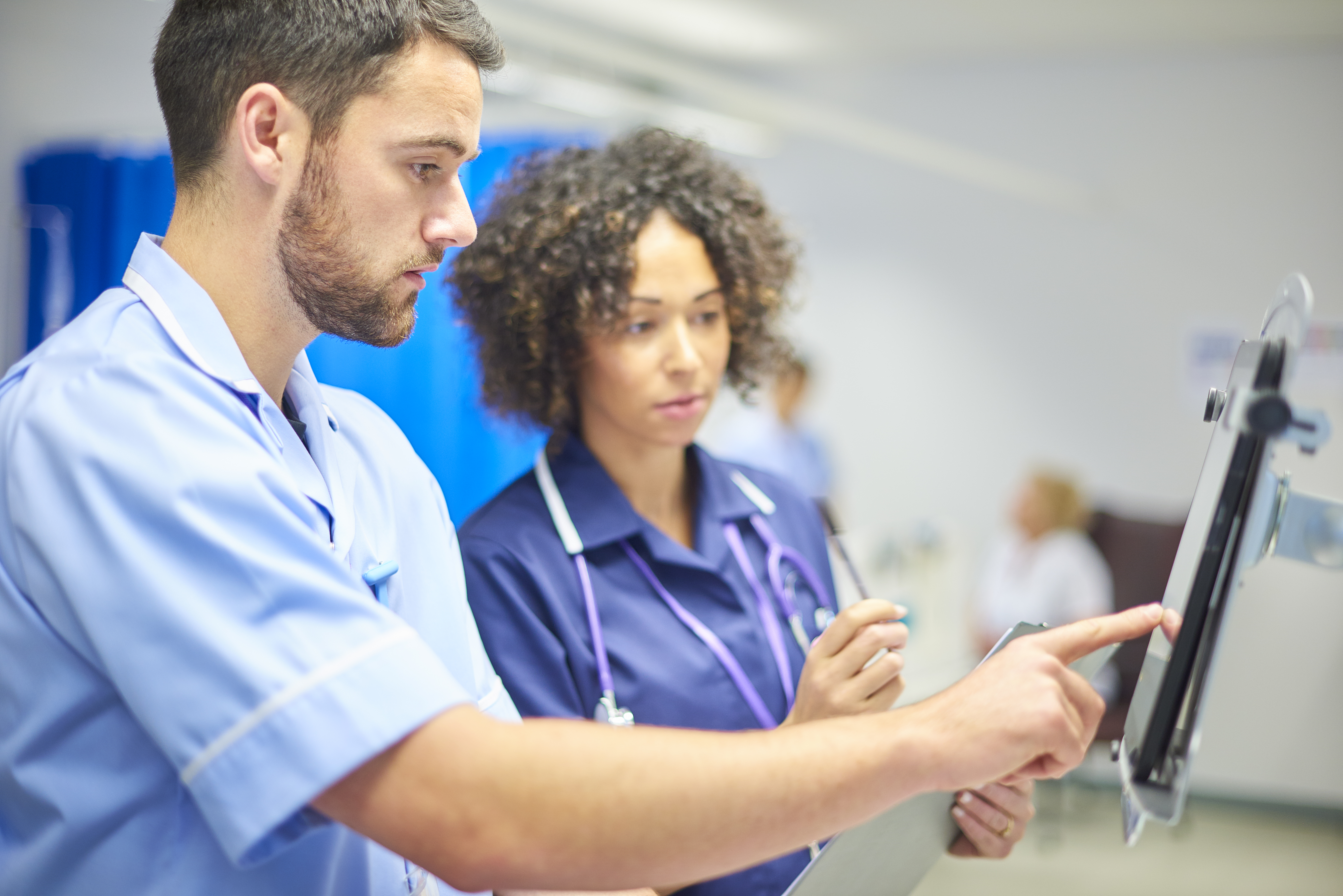 Two NHS doctors look at a screen.