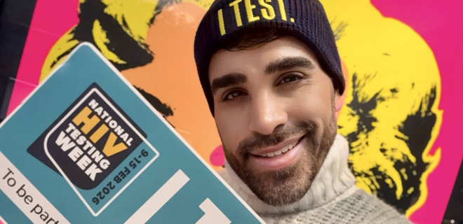 Dr Ranj holds an 'I Test' sign for National HIV Testing Week
