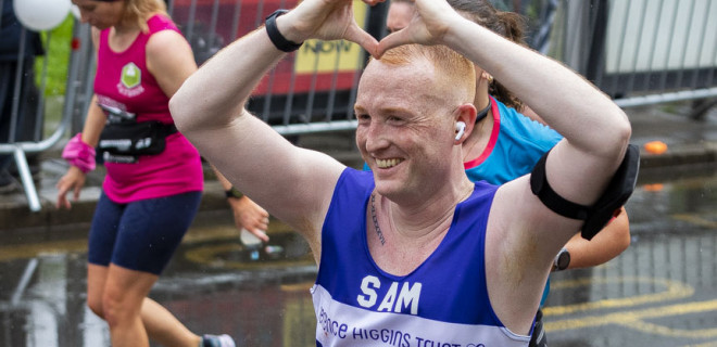 Sam running race, making heart shape with hands