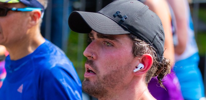 A Terrence Higgins Trust London Marathon runner clutches a water bottle mid-race.
