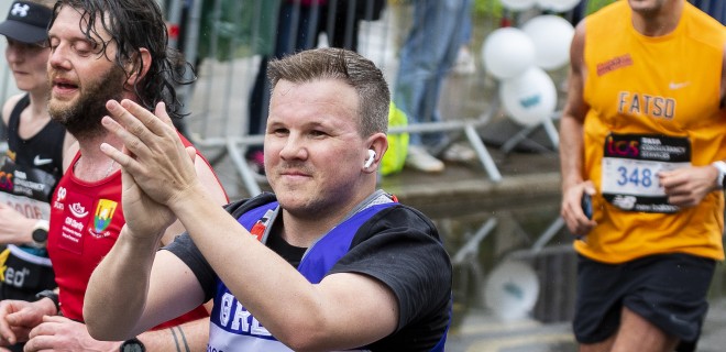 A Terrence Higgins Trust London Marathon runner clapping.