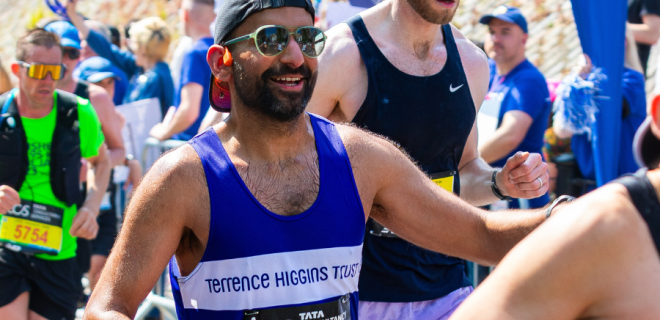 A runner with a blue Terrence Higgins Trust vest taking part in an event.