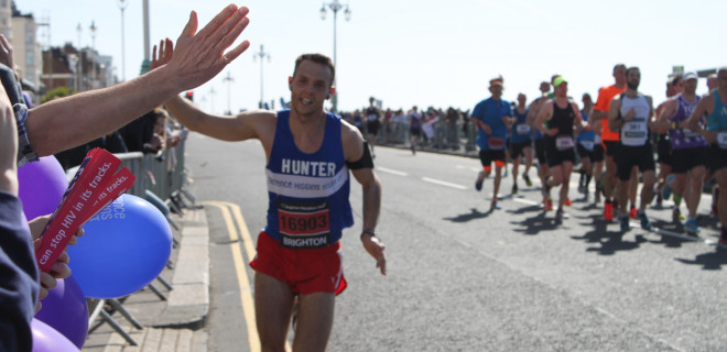 Marathon runner high-fiving crowd in Brighton