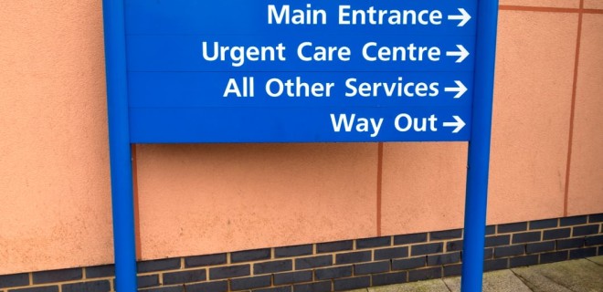 A blue sign pointing the way to a sexual health clinic