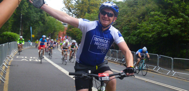 Cyclist waving in Prudential London-Surrey 100