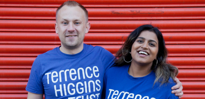 A man with his arm around a woman, both in Terrence Higgins Trust t-shirts.