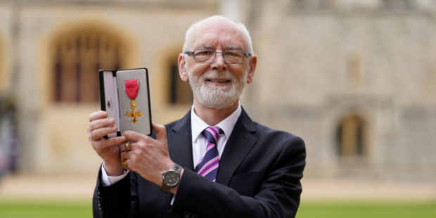 Martyn Butler holding his OBE.