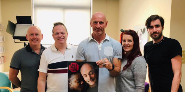 Gareth Thomas holding Can't Pass It On poster with THT staff