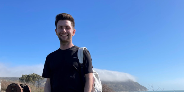 Matt Ankers stands by the coast smiling.