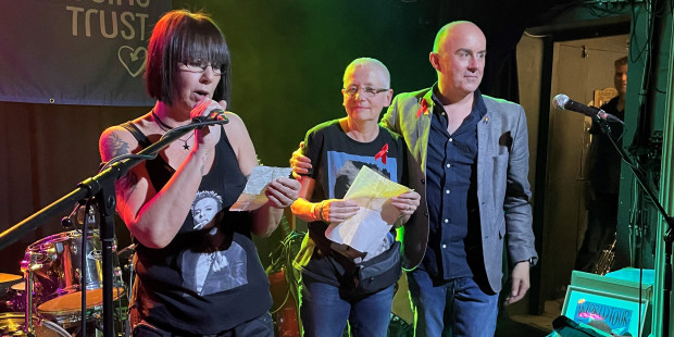Three people on a stage at David Bowie fundraising night