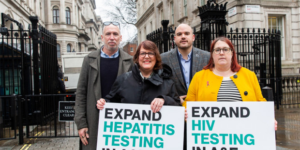 Stuart Smith, Vanessa Hebditch, Richard Angell and Deborah Gold holding signs saying 'Expand hepatitis testing in A&Es' and 'Expand HIV testing in A&Es' outside Downing Street. 