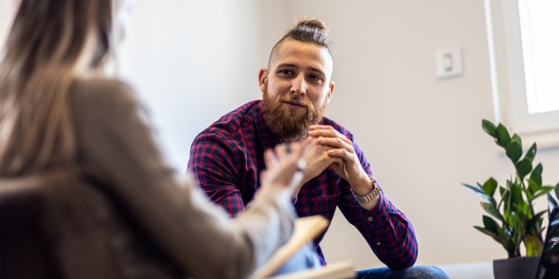 A young man in conversation with a woman.