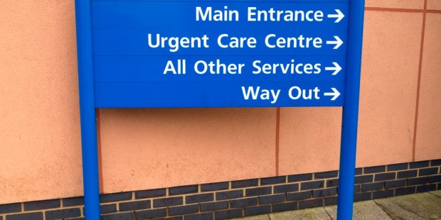A blue sign pointing the way to a sexual health clinic